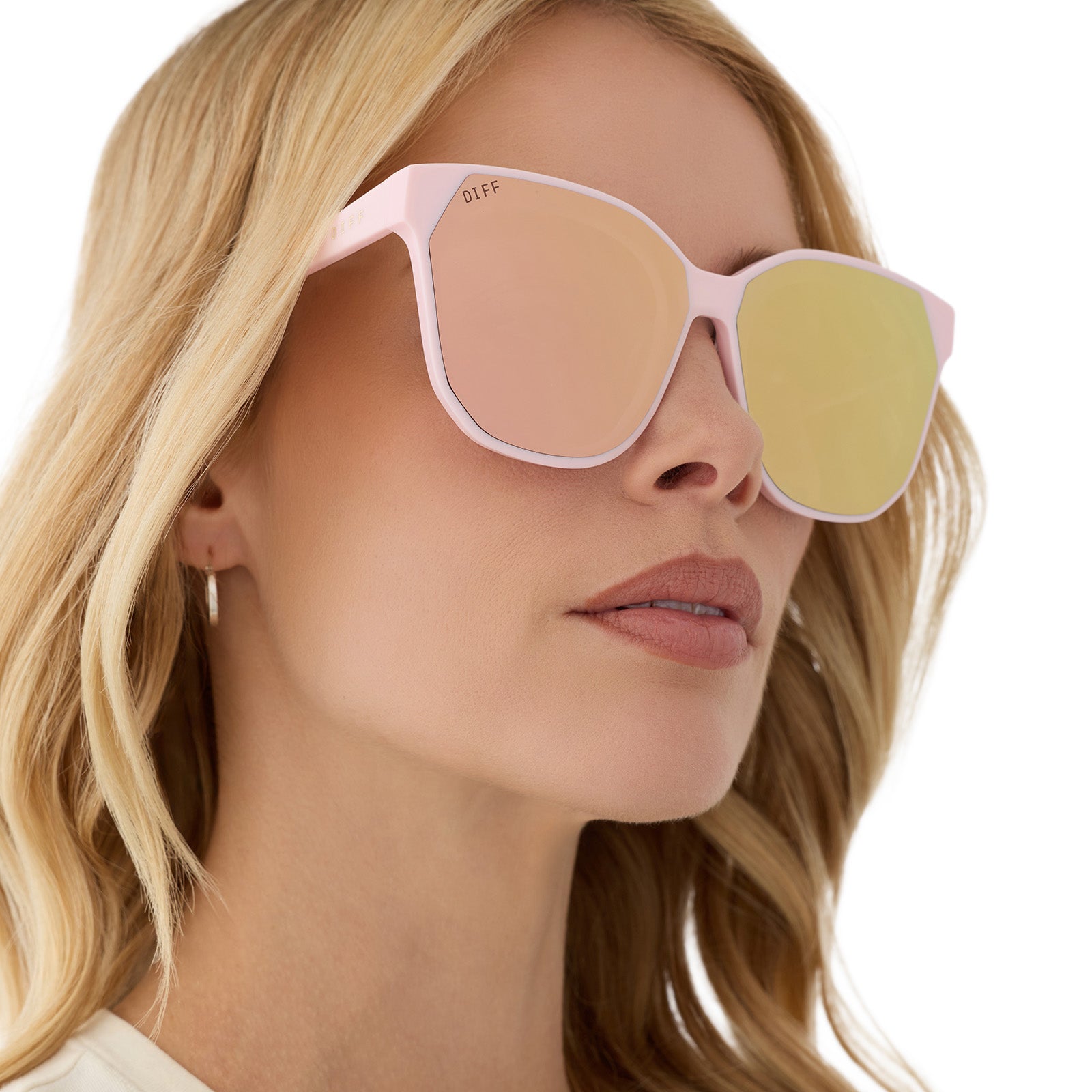 on model - female wearing diff eyewear featuring the gia square sunglasses with a powder pink frame and cherry blossom mirror lenses angled view