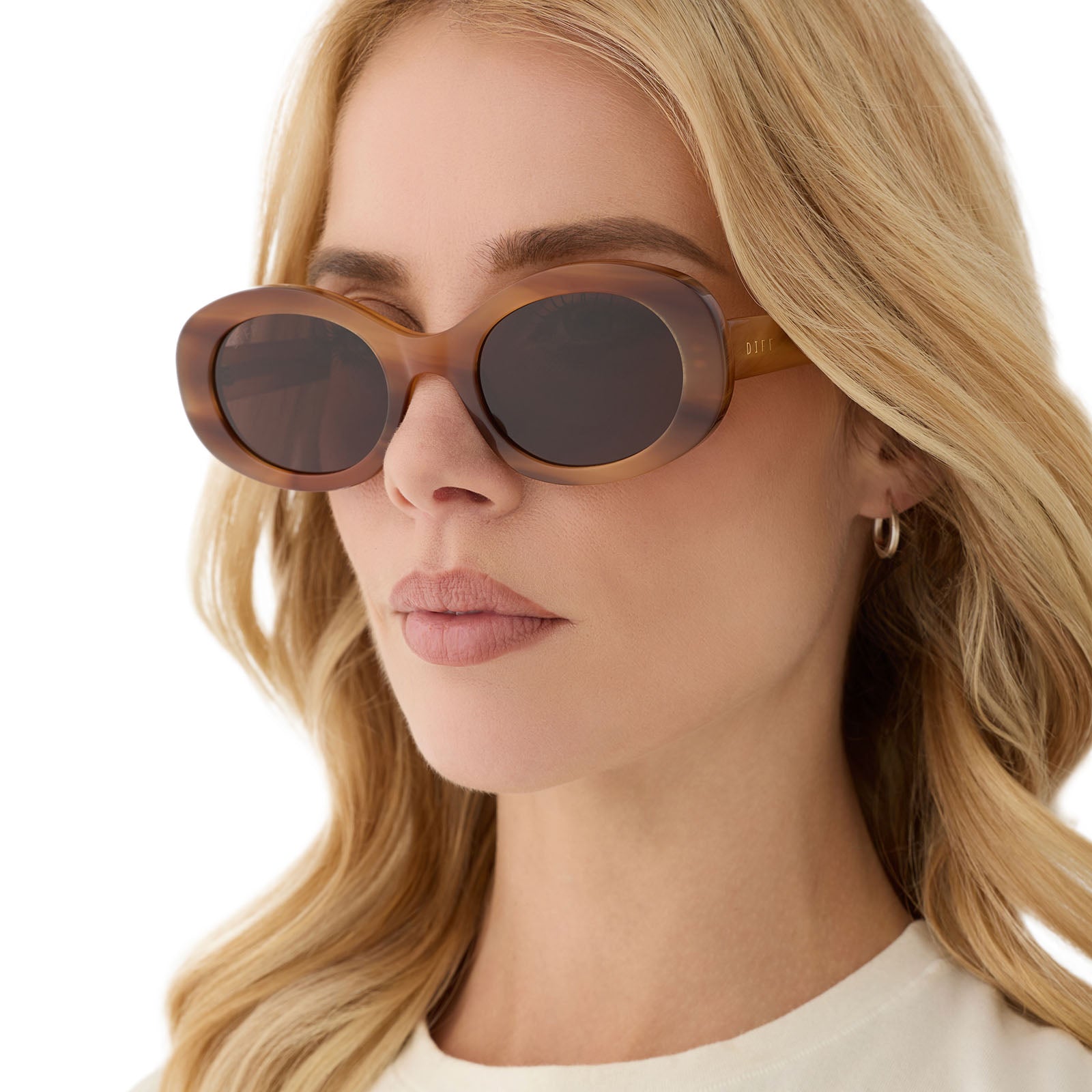 on model - female wearing diff eyewear featuring the lainey oval sunglasses with a tawny brown tortoise frame and brown lenses angled view