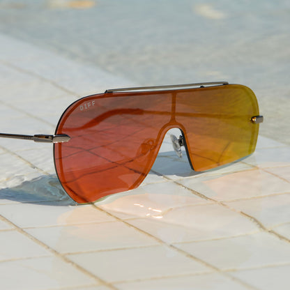 lifestyle - still life of diff eyewear imani shield sunglasses in red hot summer laying by the pool