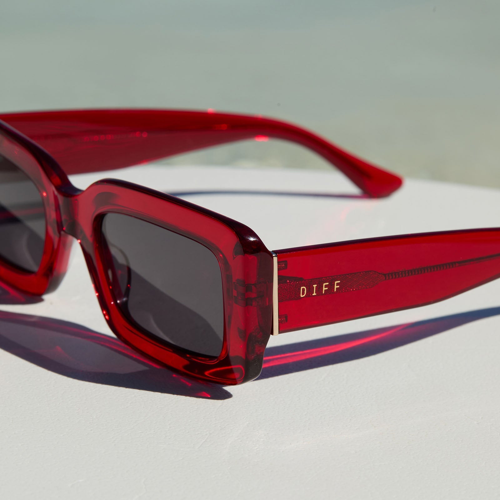lifestyle - still life of diff eyewear indy rectangular red hot summer sunglasses
