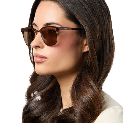 on model - female wearing diff eyewear biarritz square sunglasses with a whiskey/gold frame and brown polarized lenses angled view