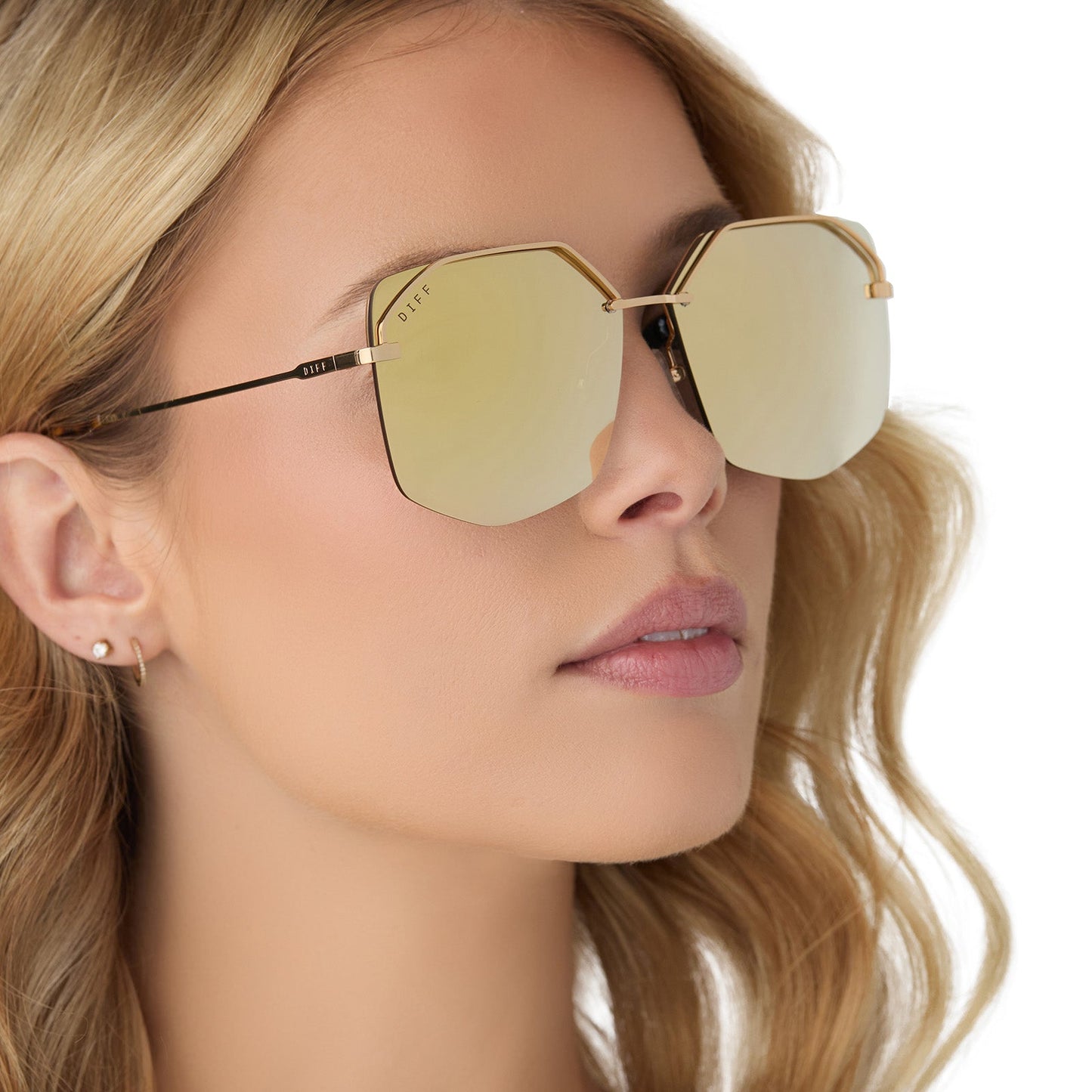 on model - female wearing diff eyewear bree oversized square sunglasses with a macchiato gold metal frame and brilliant gold mirror polarized lenses angled view