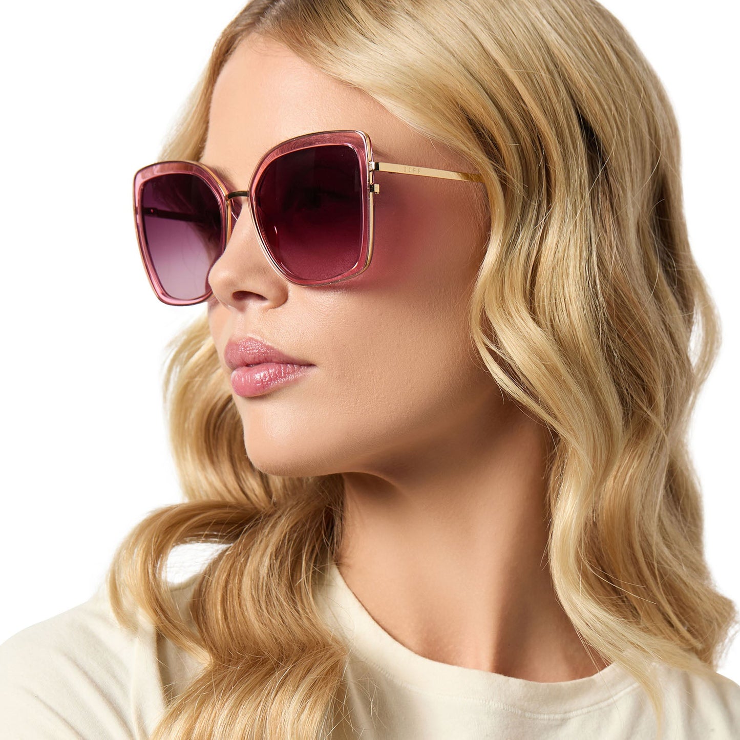 on model - female wearing diff eyewear featuring the clarisse cateye sunglasses with a candy pink crystal frame and wine gradient lenses angled view