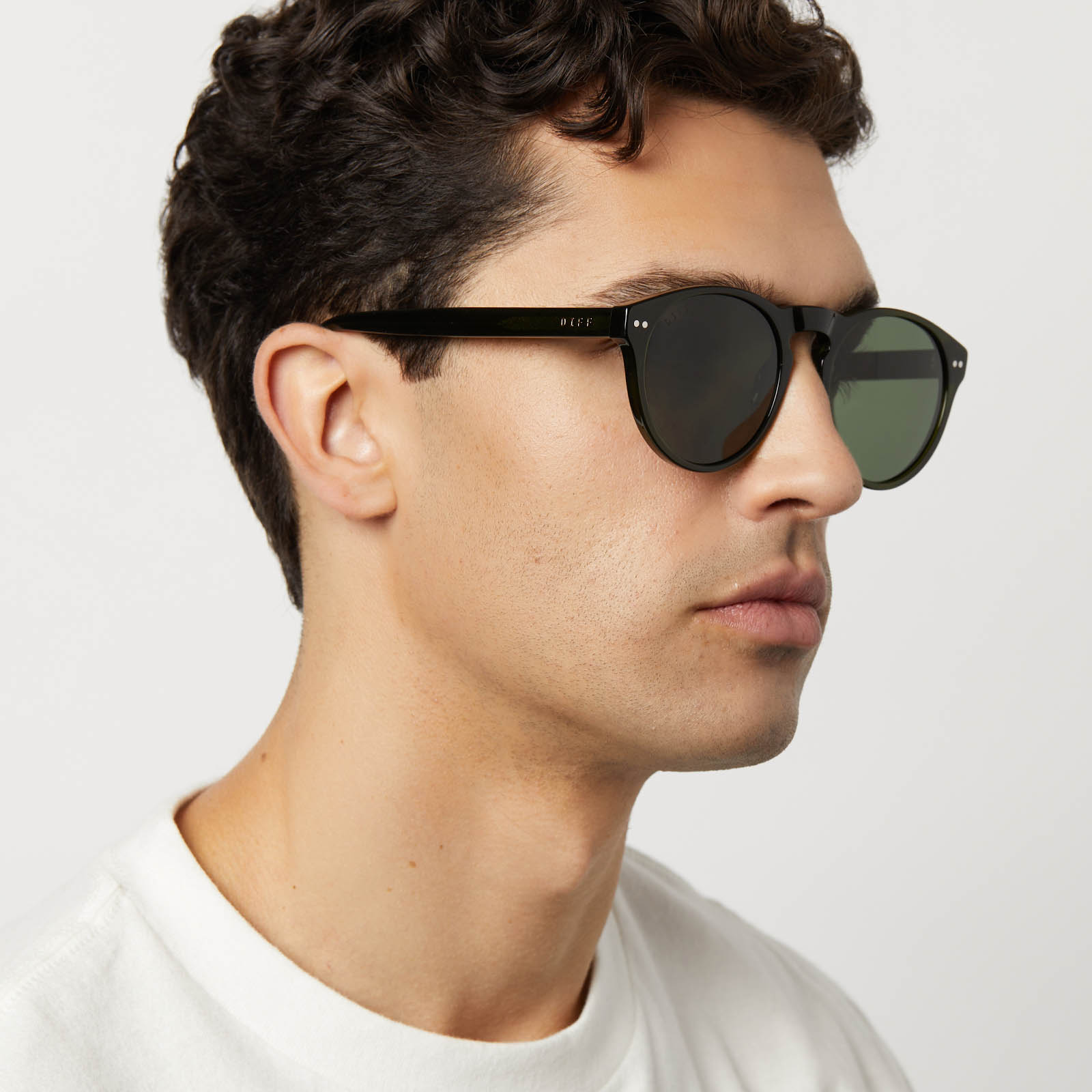 on model - male wearing diff eyewear featuring the cody xl round sunglasses with a dark olive crystal frame and g15 polarized lenses side view