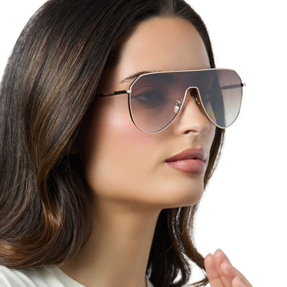 on model - female wearing diff eyewear dash shield oversized sunglasses with a gold metal frame and brown gradient lenses angled view