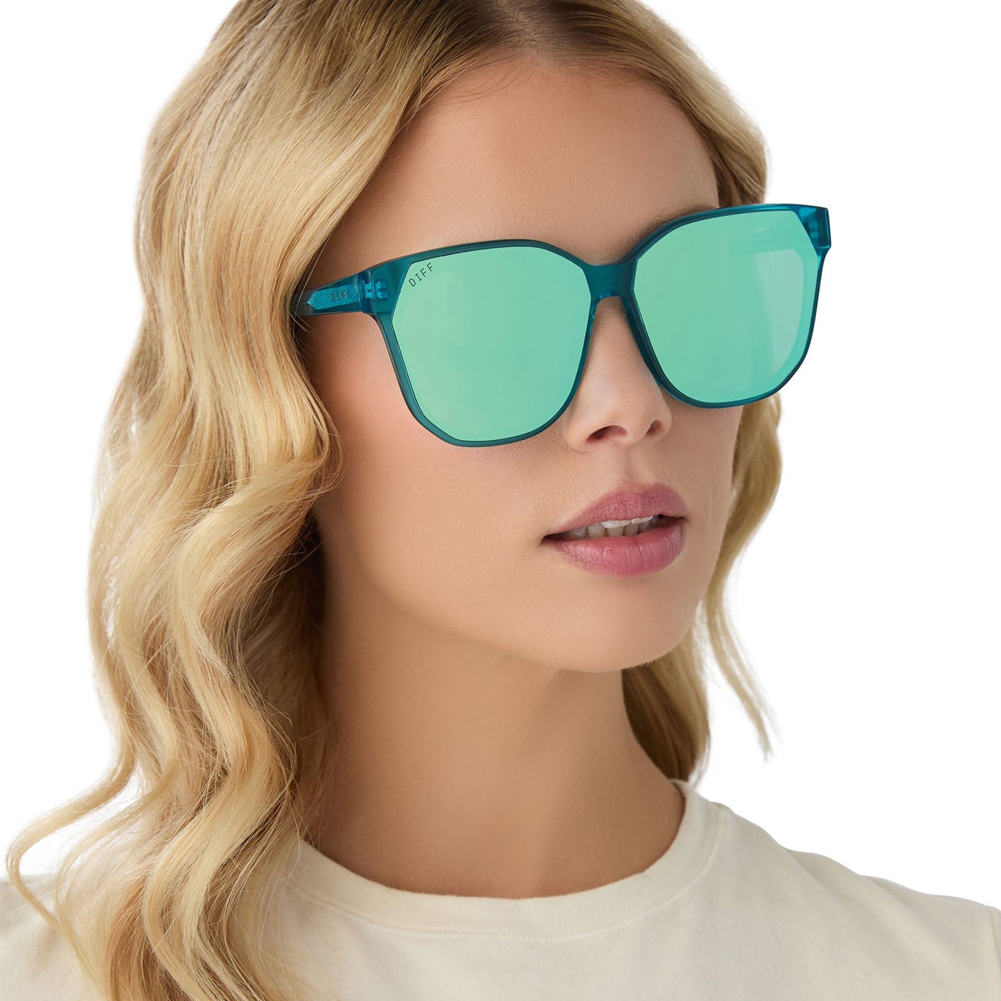 on model - female wearing diff eyewear gia oversized square sunglasses with a turquoise ice crystal acetate frame and turquoise ice mirror lenses angled view