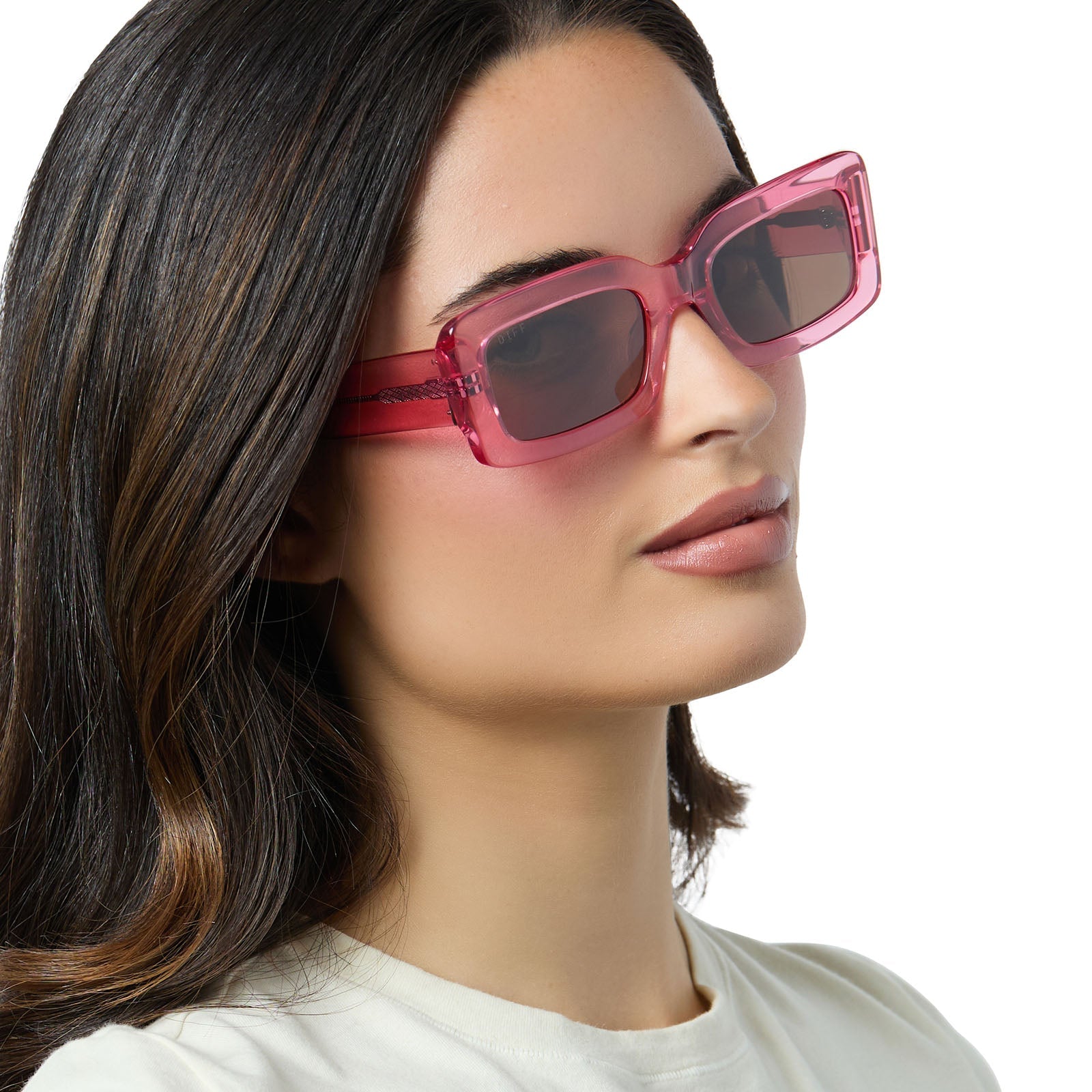 on model - female wearing diff eyewear indy square sunglasses with a candy pink crystal frame and brown lenses angled view