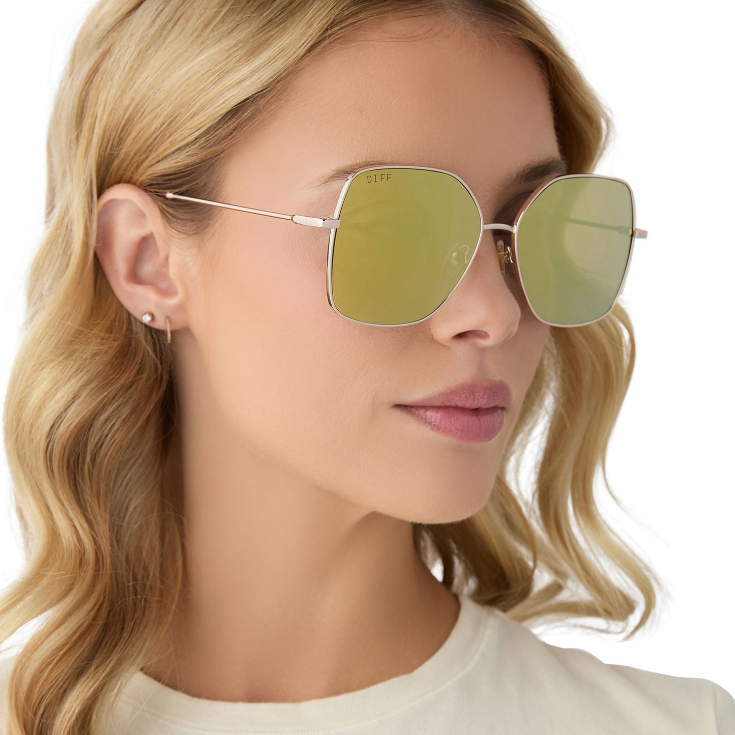 on model - female wearing diff eyewear iris square sunglasses with a gold metal frame and brilliant gold mirror lenses angled view