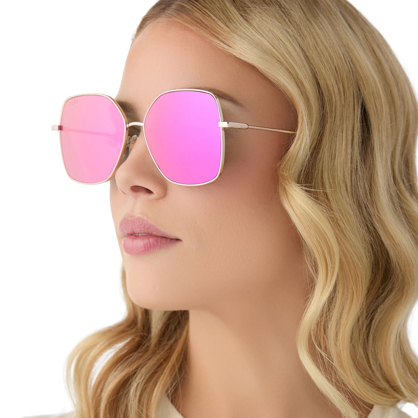 on model - female wearing diff eyewear iris square sunglasses with a gold metal frame and pink rush mirror lenses angled view