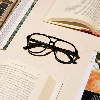 lifestyle - diff eyewear featuring the tatum aviator blue light readers with a black frame laying on a desk