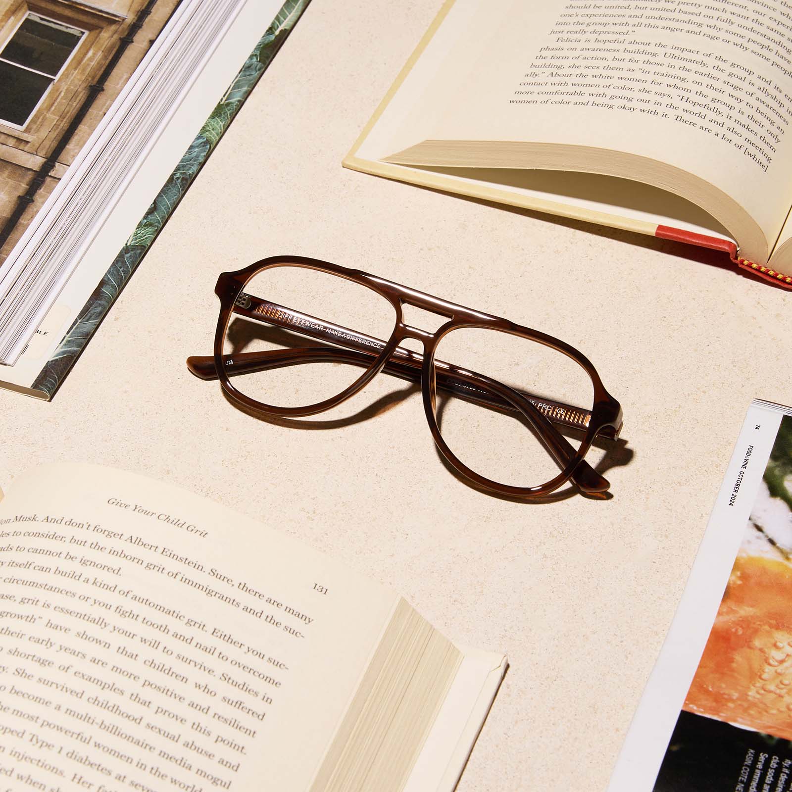 lifestyle - diff eyewear featuring the tatum aviator blue light readers with a whiskey crystal frame laying on a desk