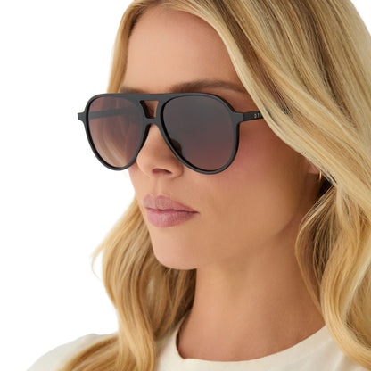 on model - female wearing diff eyewear featuring the tosca ii aviator sunglasses with a black frame and brown gradient lenses angled view