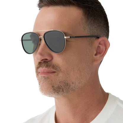 on model - male wearing yellowstone x diff eyewear featuring the yellowstone aviator sunglasses with a black frame and g15 polarized lenses angled view