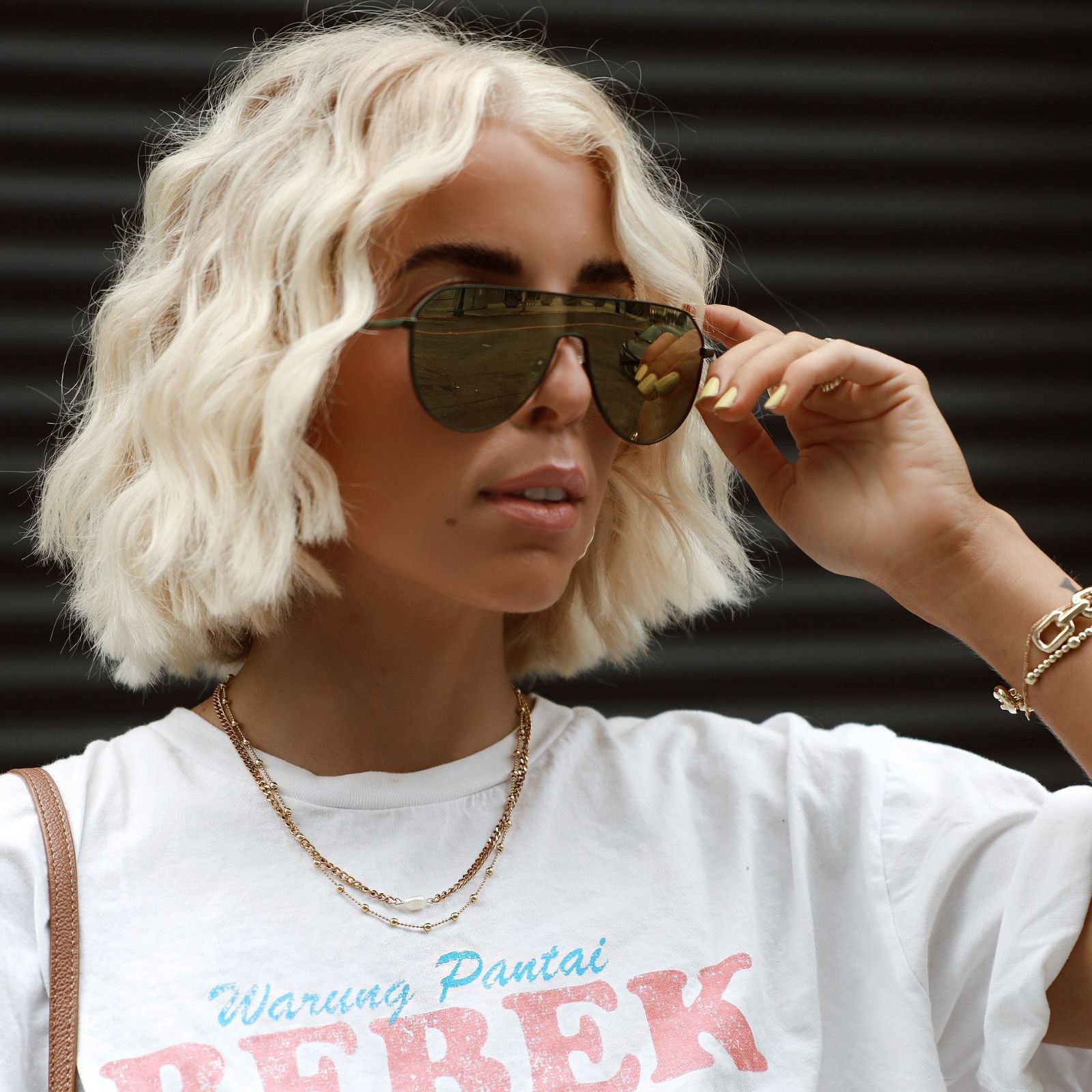 customer content - blonde model wearing dash shield gold sunglasses outdoors in white tee